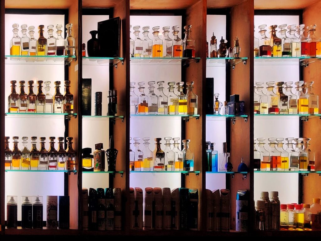 A stylish arrangement of various perfume bottles on shelves, with glass and wood elements, perfect for fragrance enthusiasts.